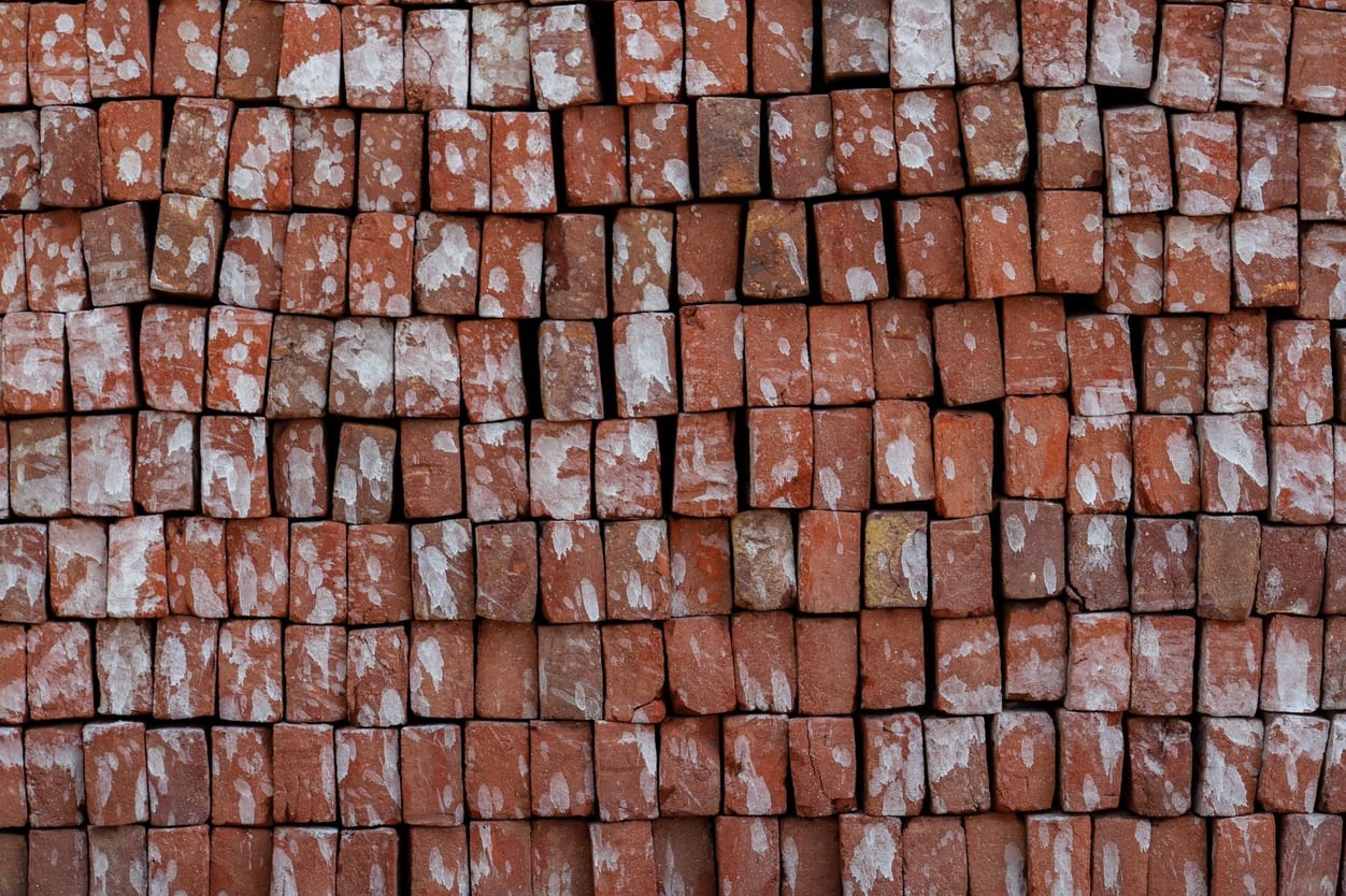Pilha de tijolos de cerâmica vermelha empilhados para construção